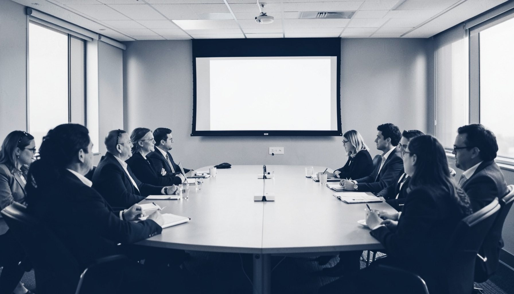 Duotone corporate conference room with attendees and presentation screen, navy blue and pale silver tones
